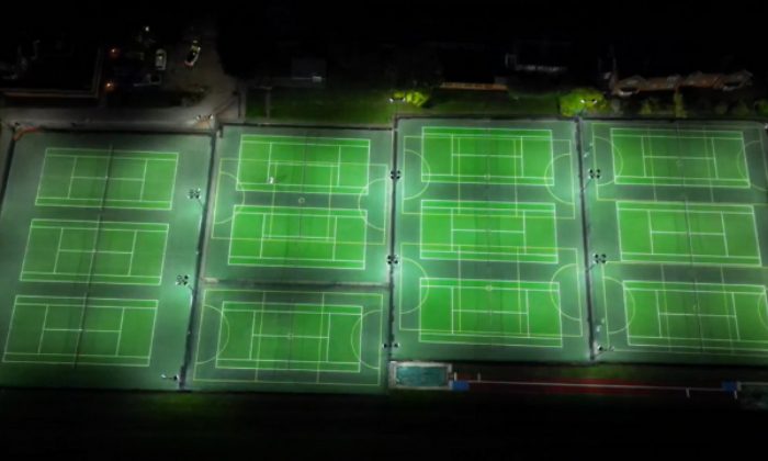 aerial view of tennis courts with exterior lighting